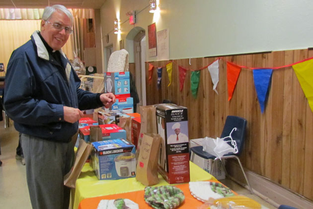 Father Steven Bossi, CSP, drops in his ticket to win one of the numerous raffle prizes available at the Fall Fair of St. Peter's Church, Toronto.